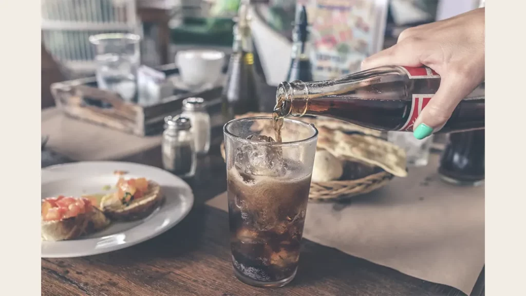 A woman pouring a drink into a glass