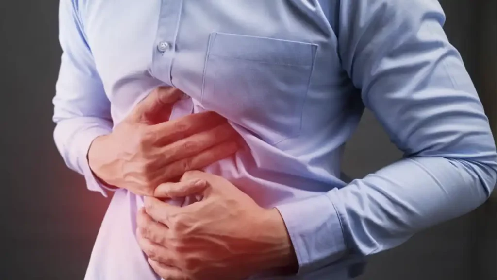 A man with his hands on his stomach due to acid reflux.
