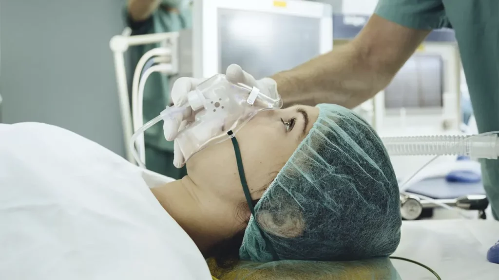 A woman undergoing general anesthesia in the operating room.