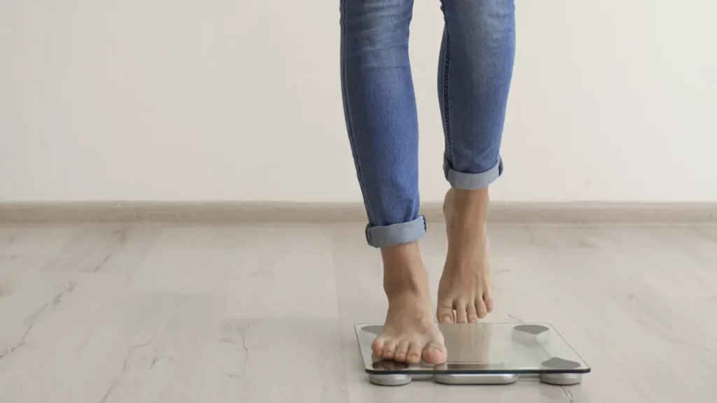 Woman celebrating her rapid weight loss on the scale